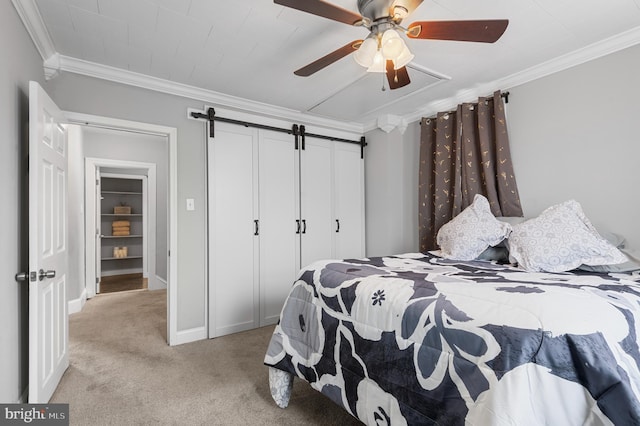 carpeted bedroom with ceiling fan, a barn door, and crown molding