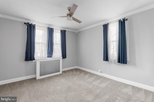 spare room featuring carpet floors, crown molding, radiator heating unit, and ceiling fan