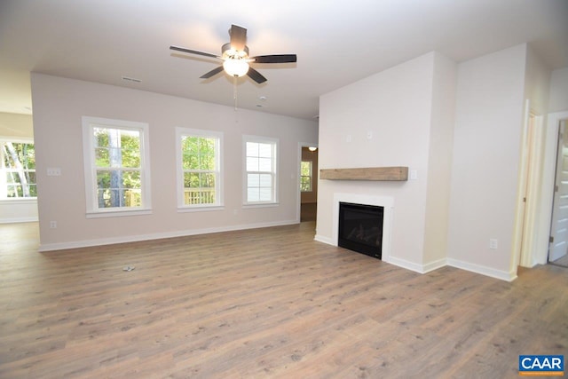 unfurnished living room featuring hardwood / wood-style floors and ceiling fan