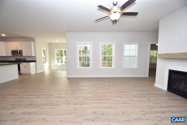 unfurnished living room with ceiling fan and light hardwood / wood-style floors