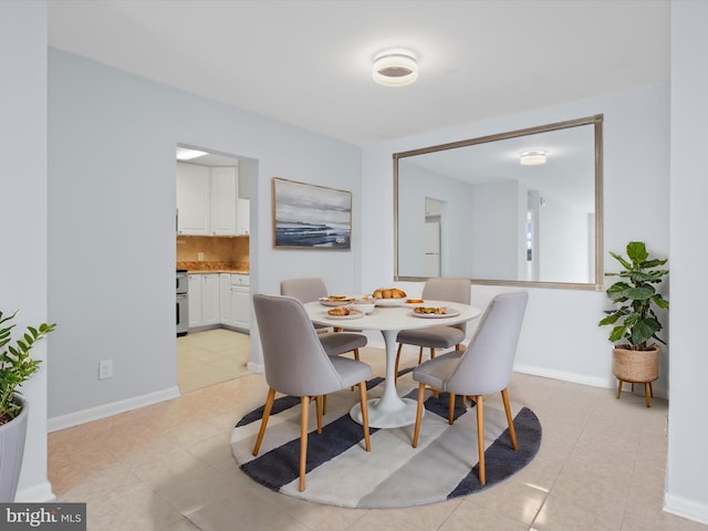 dining space featuring light tile patterned flooring and baseboards