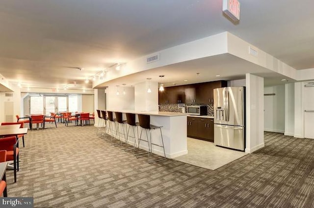 kitchen with light carpet, dark brown cabinetry, visible vents, appliances with stainless steel finishes, and light countertops