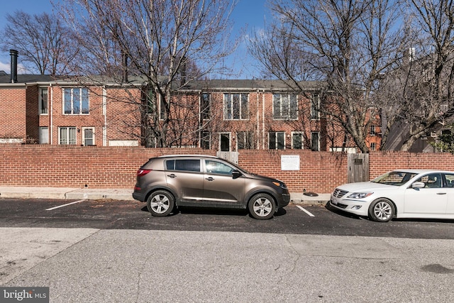 townhome / multi-family property featuring fence and brick siding