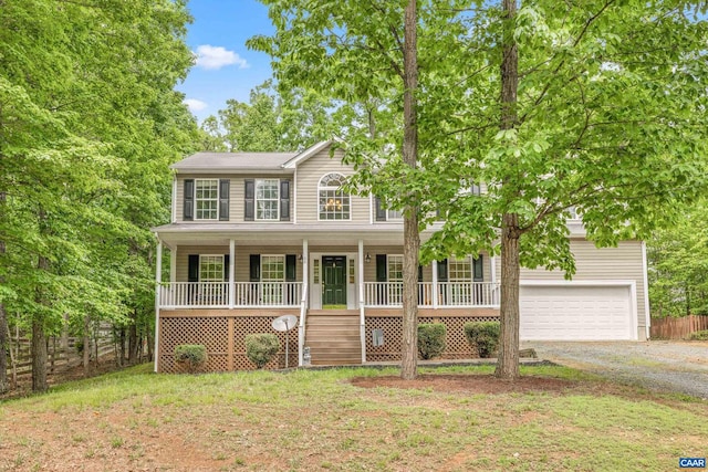 view of front of property featuring a garage, a front lawn, and covered porch