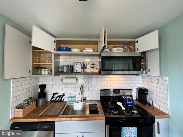 kitchen featuring appliances with stainless steel finishes, decorative backsplash, sink, and white cabinetry