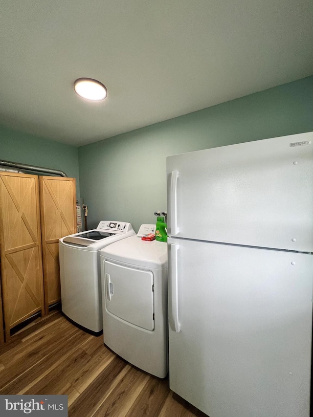 laundry area featuring washing machine and clothes dryer and wood-type flooring