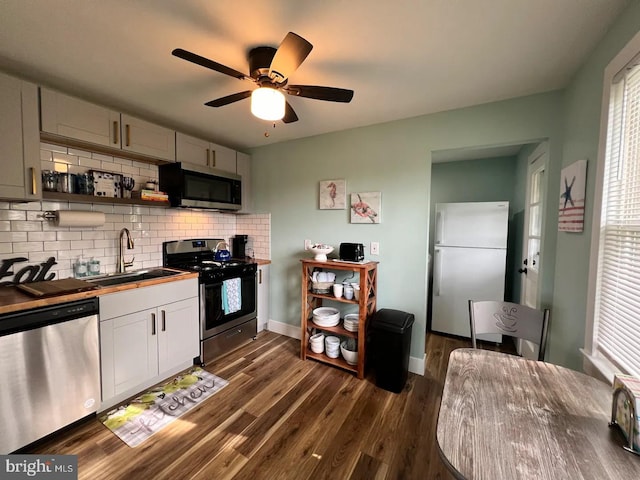 kitchen featuring ceiling fan, dark wood-type flooring, a wealth of natural light, appliances with stainless steel finishes, and sink