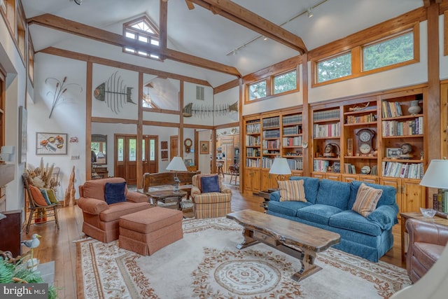 living room featuring hardwood / wood-style flooring, plenty of natural light, rail lighting, and high vaulted ceiling