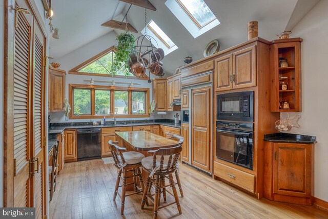 130 Mcfee St, Lewes, DE 19958 - kitchen with black appliances, a skylight, beam ceiling, light wood-style floors, and brown cabinetry