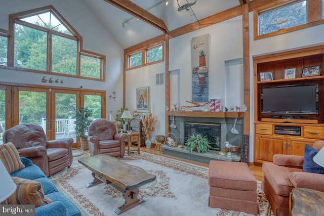 130 Mcfee St, Lewes, DE 19958 - living area featuring high vaulted ceiling, a glass covered fireplace, wood finished floors, plenty of natural light, and beam ceiling