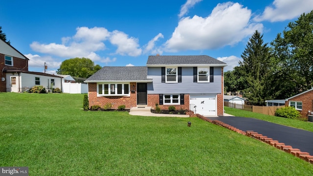 tri-level home featuring a garage and a front yard