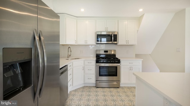 kitchen featuring appliances with stainless steel finishes, white cabinetry, and sink