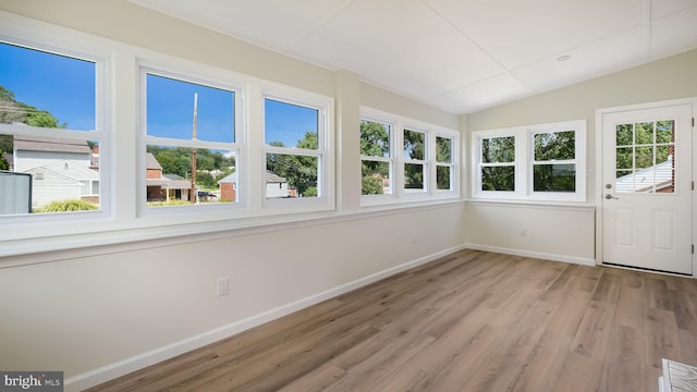 unfurnished sunroom featuring plenty of natural light and vaulted ceiling