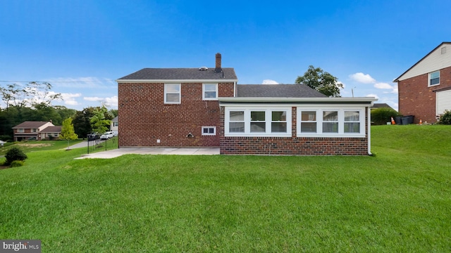 rear view of property with a yard and a patio