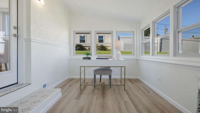 sunroom / solarium featuring vaulted ceiling and a healthy amount of sunlight