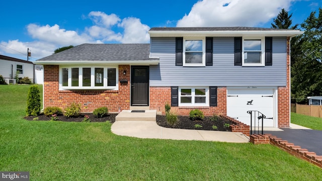 split level home featuring a garage and a front lawn