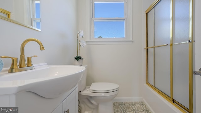 full bathroom featuring tile patterned floors, toilet, bath / shower combo with glass door, and vanity