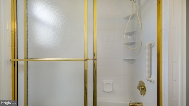 bathroom featuring combined bath / shower with glass door