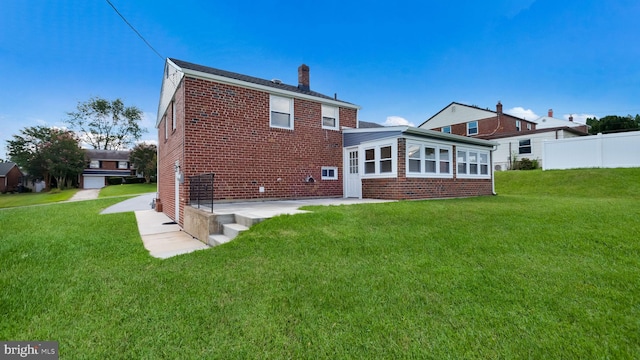 rear view of house featuring a lawn