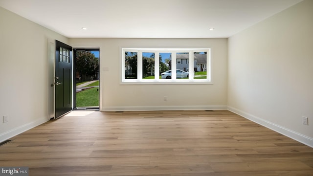 spare room with plenty of natural light and light hardwood / wood-style floors