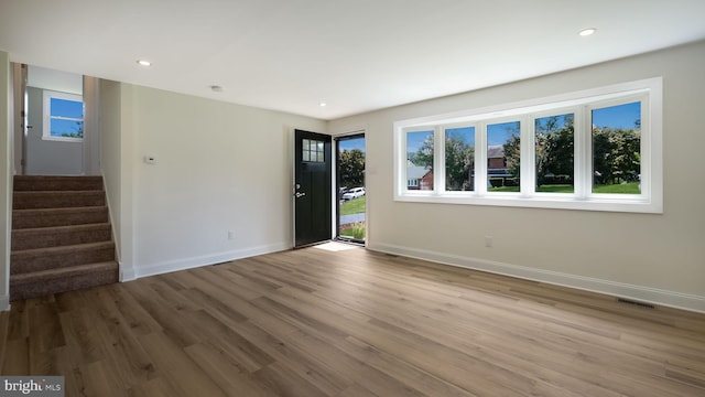 spare room with a wealth of natural light and hardwood / wood-style flooring