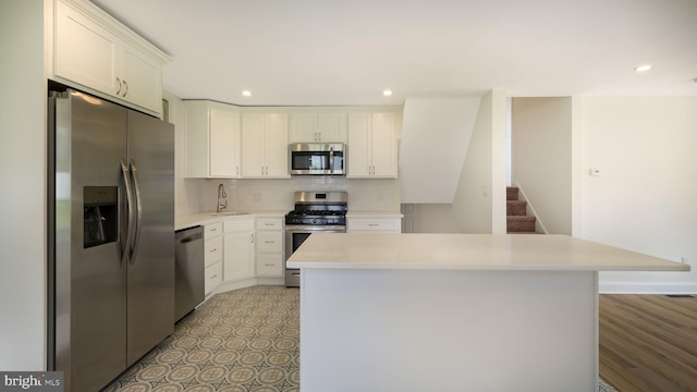 kitchen featuring stainless steel appliances, sink, decorative backsplash, light wood-type flooring, and white cabinets