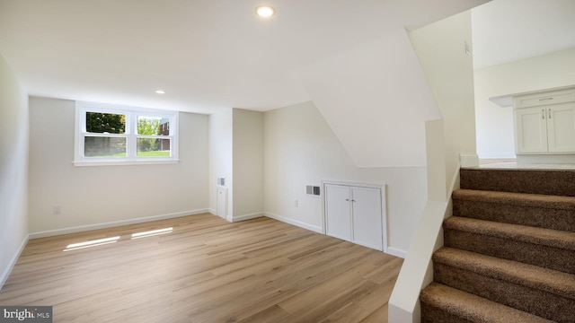 bonus room featuring light wood-type flooring and vaulted ceiling