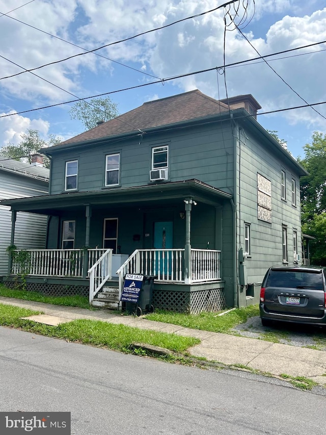 view of front facade with cooling unit and a porch