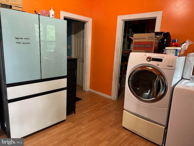 laundry room featuring light wood-type flooring and washing machine and clothes dryer