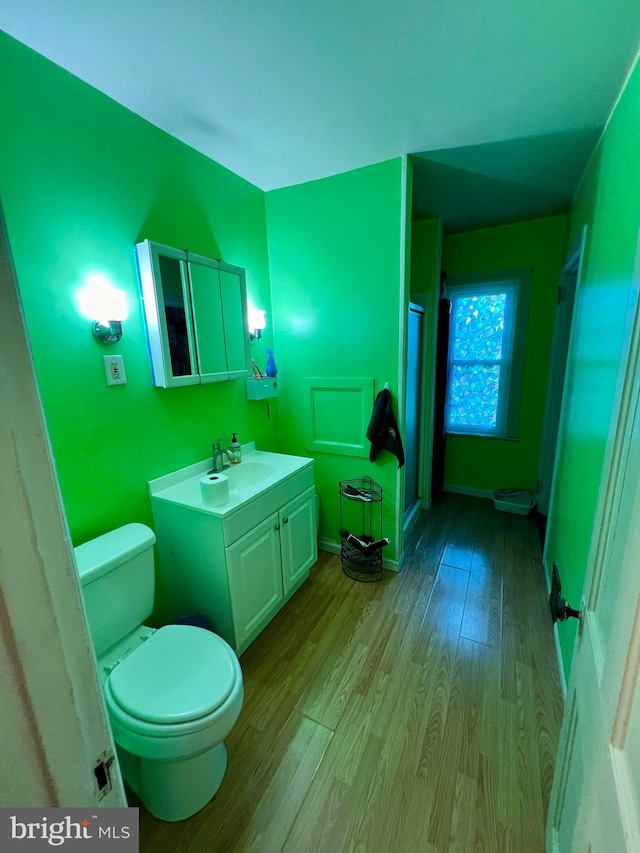 bathroom featuring wood-type flooring, vanity, and toilet