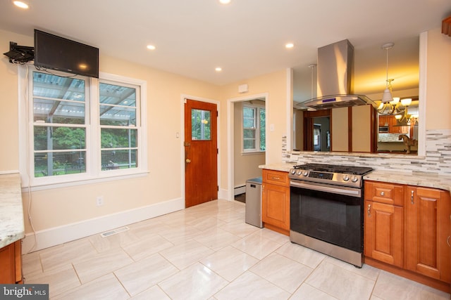 kitchen featuring decorative backsplash, island exhaust hood, stainless steel range with gas cooktop, and light tile patterned floors