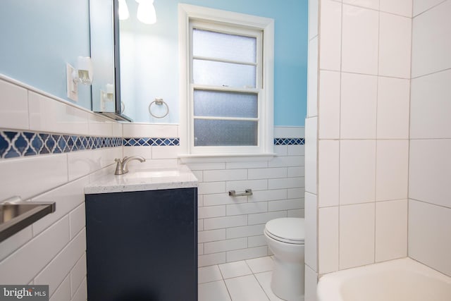 bathroom featuring tile walls, vanity, tile patterned floors, and toilet