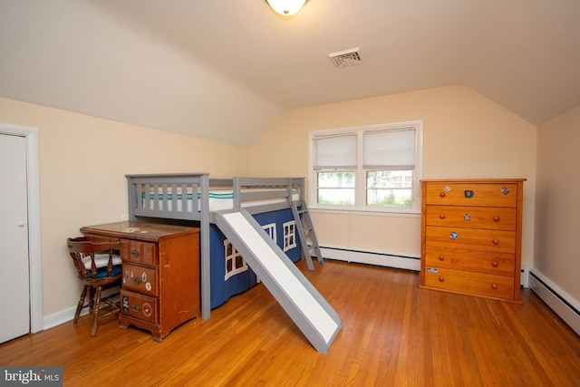 bedroom featuring vaulted ceiling, baseboard heating, and wood-type flooring