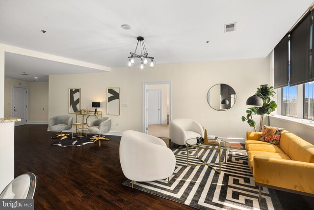 living room with an inviting chandelier and dark hardwood / wood-style flooring