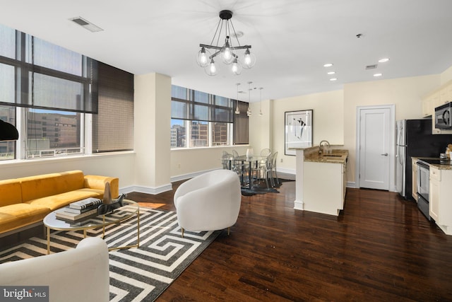 living room with sink, dark hardwood / wood-style flooring, and an inviting chandelier