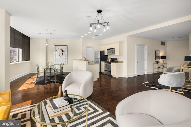 living room with dark wood-type flooring and a notable chandelier