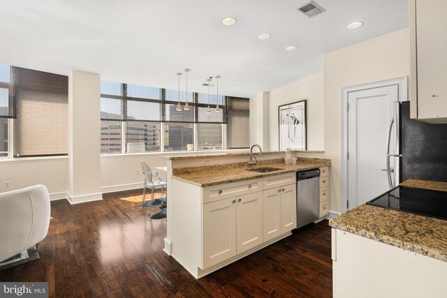 kitchen featuring appliances with stainless steel finishes, sink, light stone counters, and white cabinets