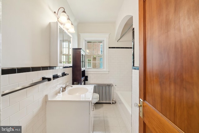 bathroom featuring tile walls, vanity, tile patterned flooring, radiator, and toilet