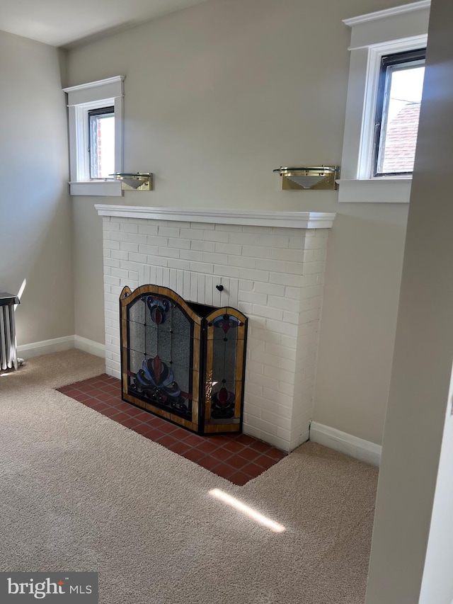 interior space with a brick fireplace and carpet floors