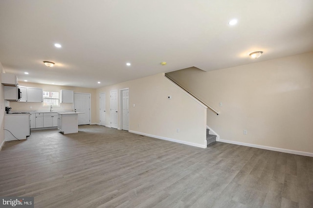 unfurnished living room featuring sink and light wood-type flooring