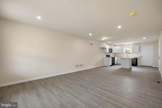 unfurnished living room with light hardwood / wood-style floors and sink