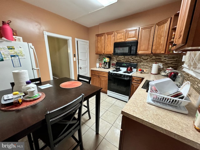 kitchen with sink, backsplash, light tile patterned flooring, and white appliances