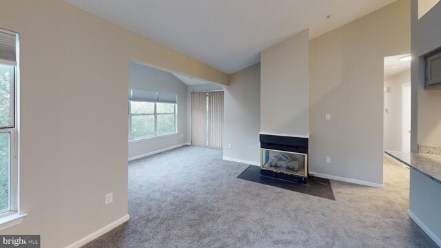 unfurnished living room with carpet floors and lofted ceiling