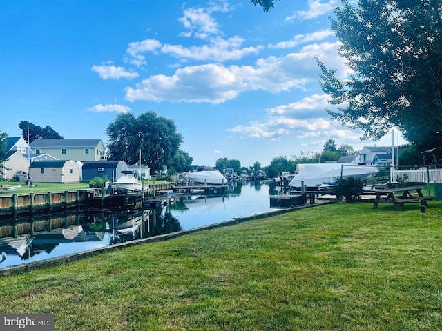 dock area with a yard and a water view