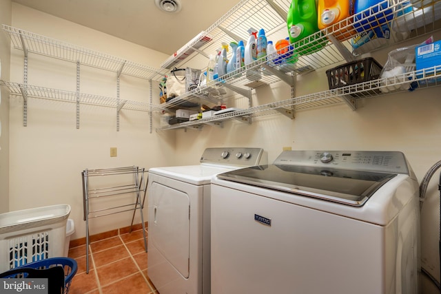 laundry area featuring tile patterned floors and washing machine and dryer