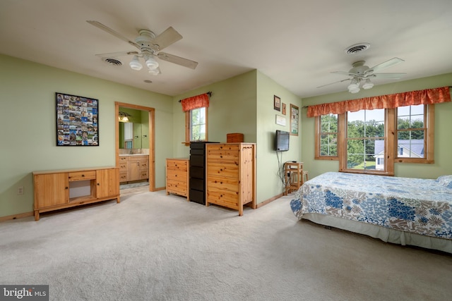 bedroom featuring ceiling fan, connected bathroom, and light carpet