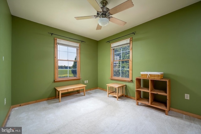 misc room featuring ceiling fan and light carpet