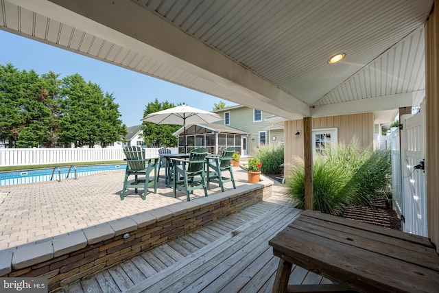 wooden deck with a patio area and a fenced in pool