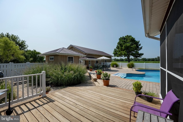 wooden deck with a fenced in pool and a patio area