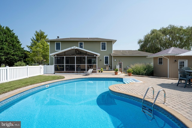 view of swimming pool featuring a sunroom and a patio area